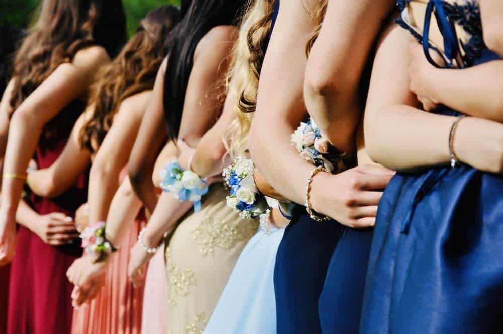 Several people in prom dresses posing for a picture